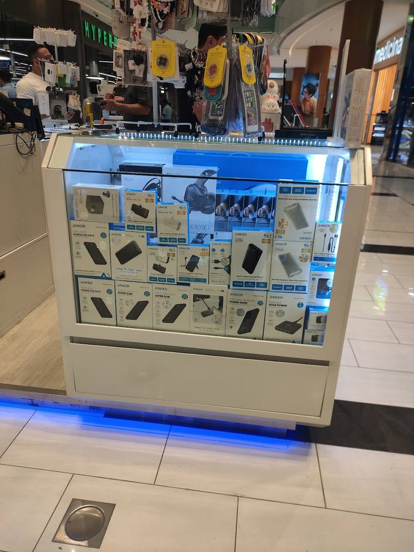 Boxed chargers and cables in a lit glass cabinet with a blue glow underneath